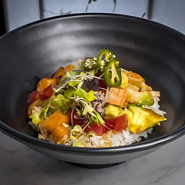 Min Sushi poke bowl with rice, salmon, avocado, jalapeños, and microgreens in a black bowl.