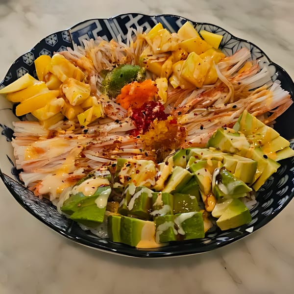 Min Sushi poke bowl with crab meat, mango, avocado, and roe in a decorative bowl.