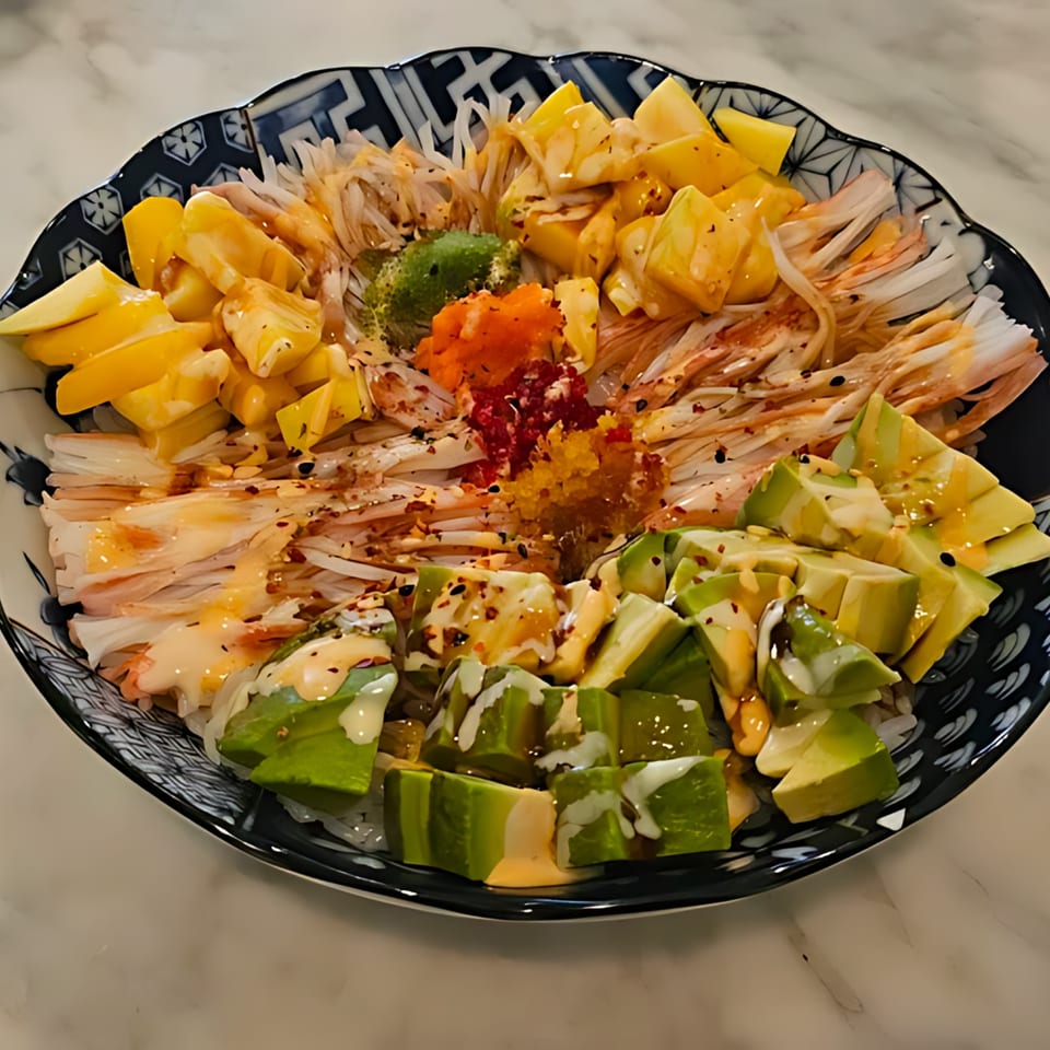 Min Sushi poke bowl with crab meat, mango, avocado, and roe in a decorative bowl.